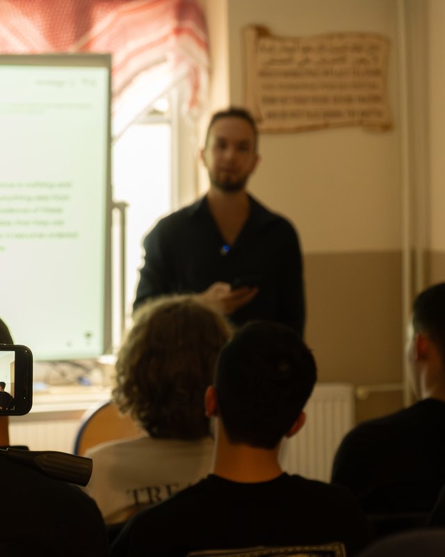 man holding a lecture in front of a group of people